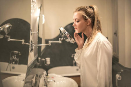 A-woman-with-acne-looking-in-the-mirror
