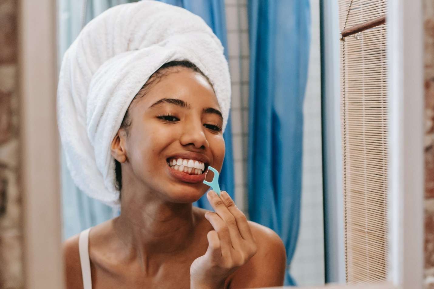 Woman cleaning her teeth with dental floss