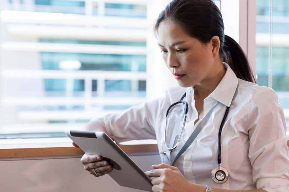 A doctor talking to a patient through a tablet