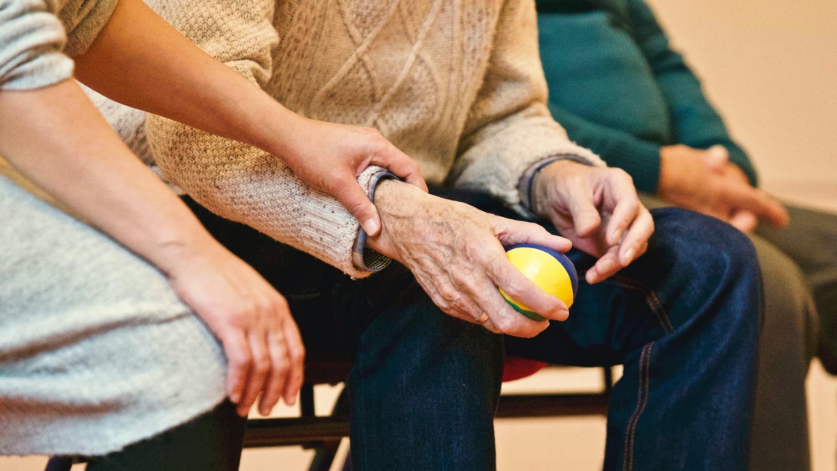 Person holding elderly man’s hand