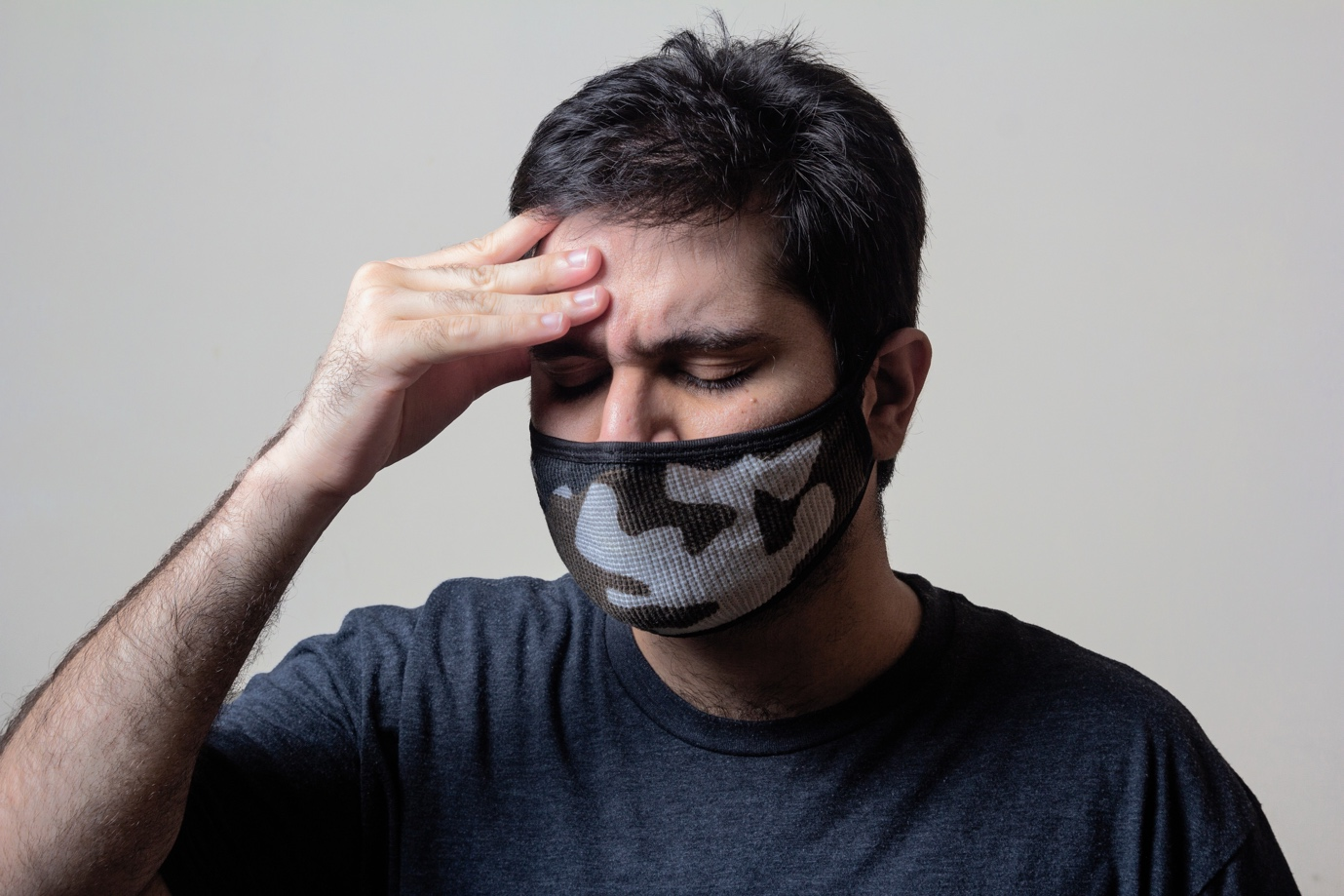 A person having a headache holding their head