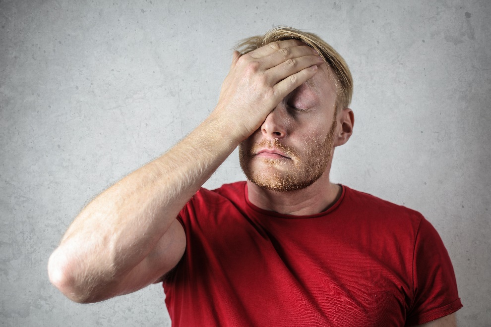 Man wearing a red shirt sitting worried