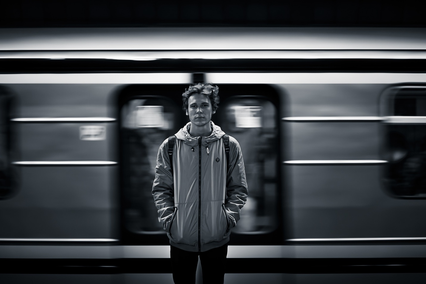 Man standing in front of a train going by.