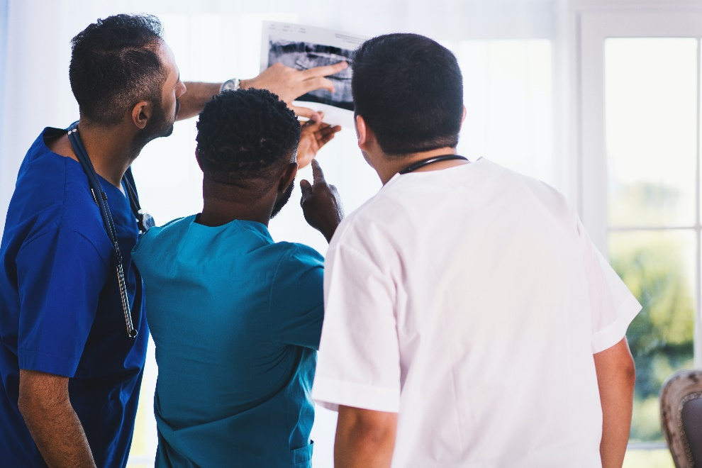 three medical professionals looking at a report