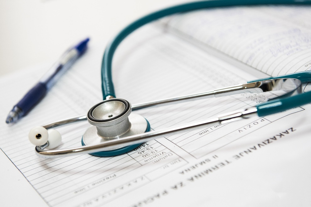 a stethoscope and a pen lying on a sheet
