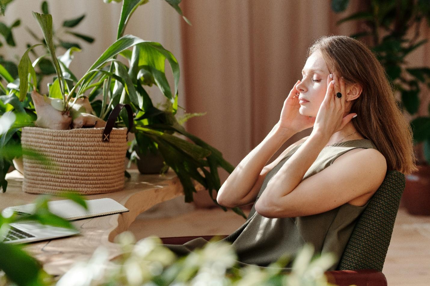 A woman sitting with her hands on her temple