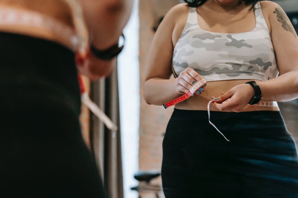 Woman measuring her waist with tape