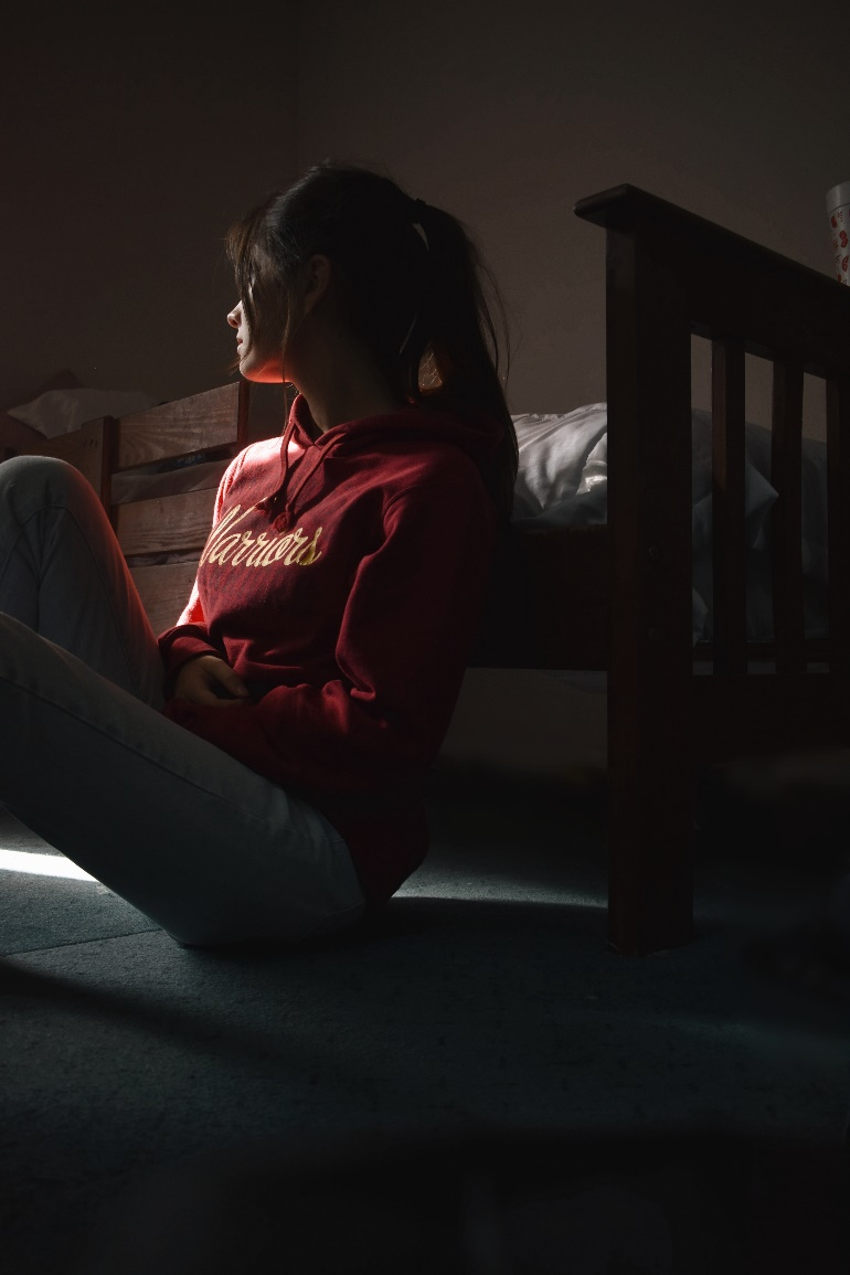 A sad girl sitting in her room