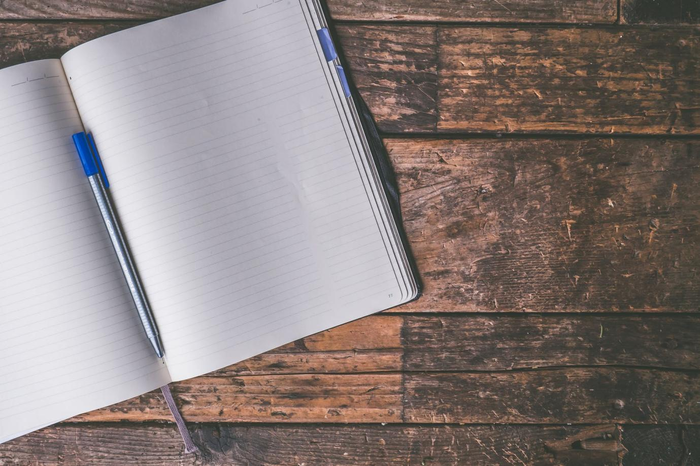 An open notebook with a pen
