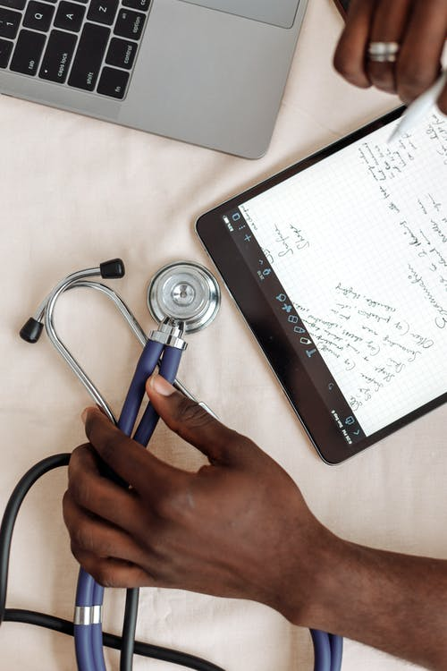 A healthcare provider taking notes during an online doctor visit