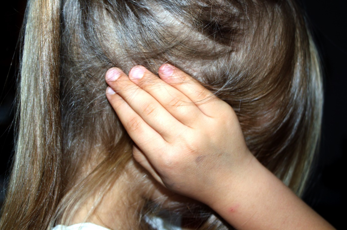 A girl holding her ear due to pain