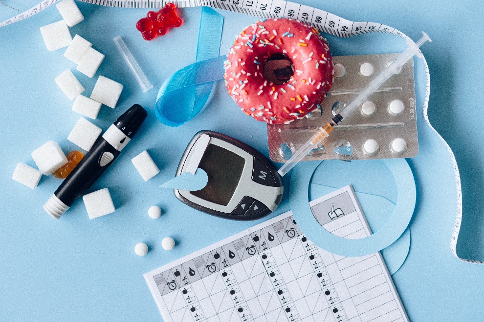 Sprinkled donut lying next to glucometer