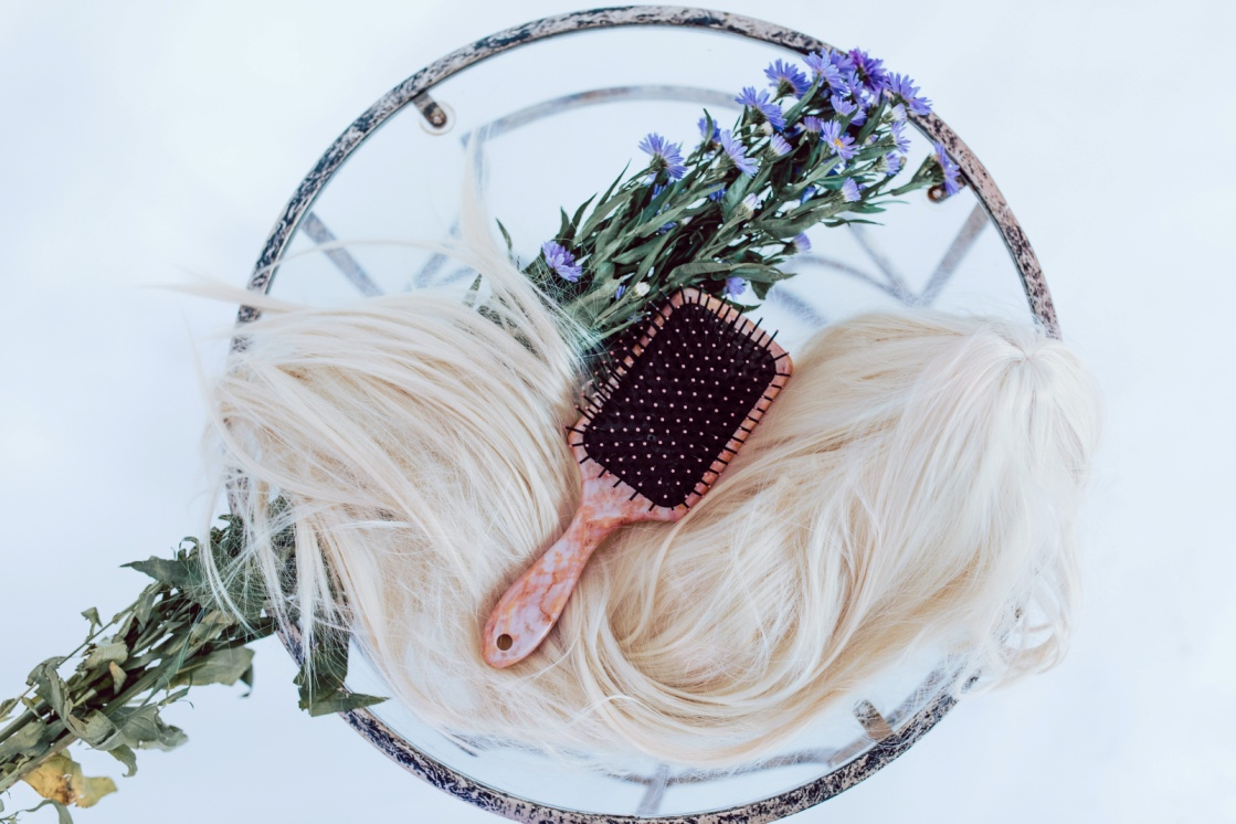 A hair brush placed over a wig