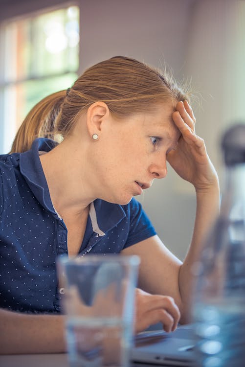 A woman holding her head in stress