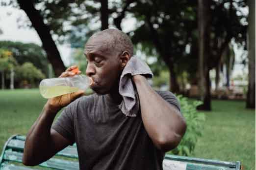 man-drinking-and-wiping-sweat