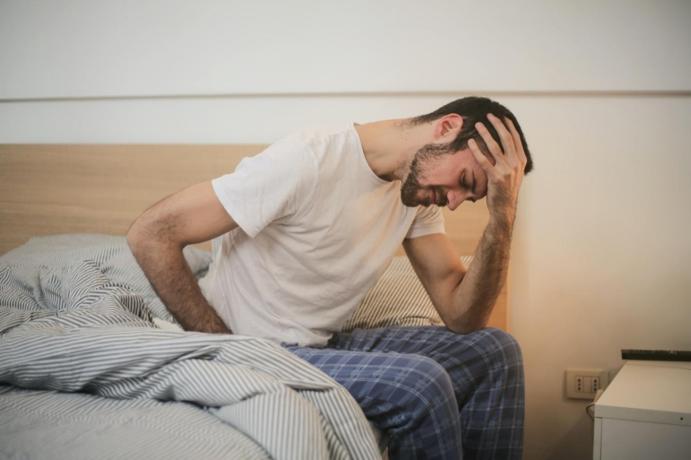 A sick man sitting on a bed