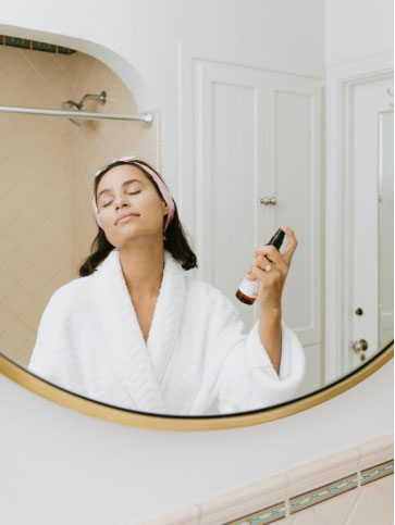 a woman applying a skincare product