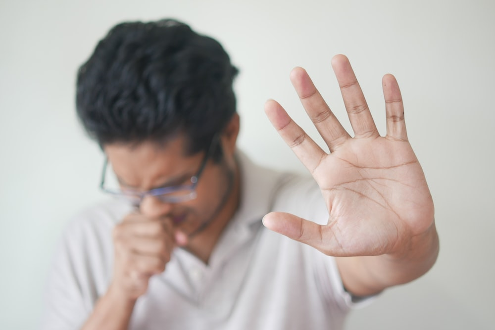 A man coughing due to strep throat infection