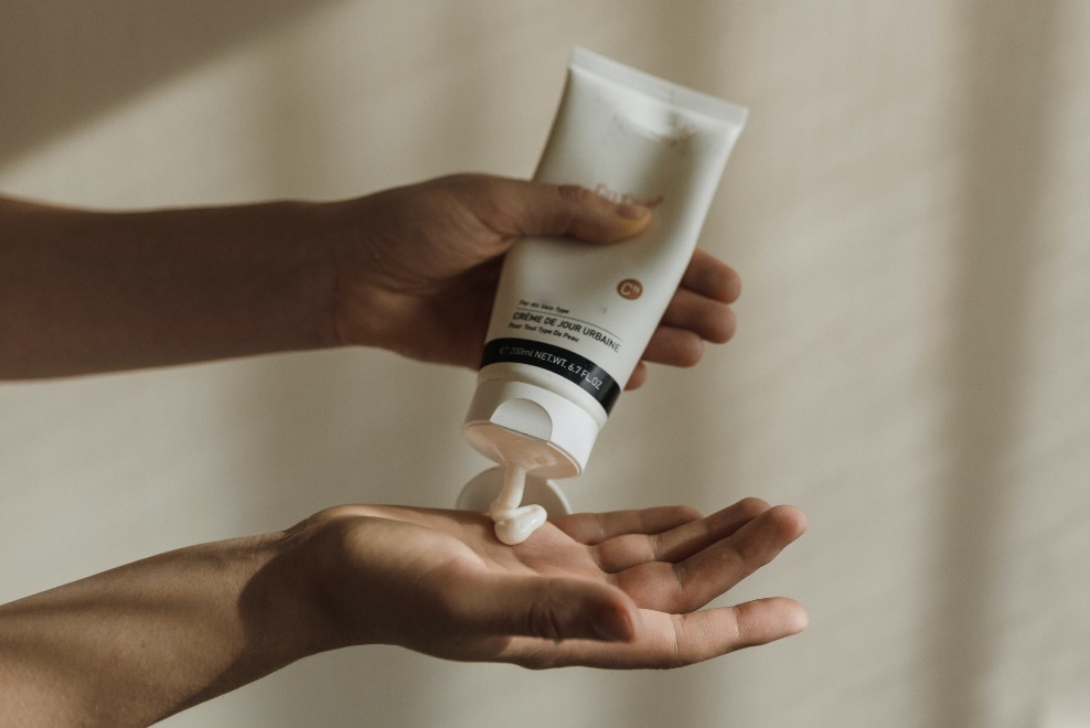 Person squeezing a white tube
