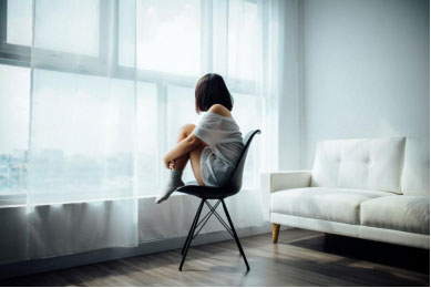 A woman looking depressed gazing out the window 
