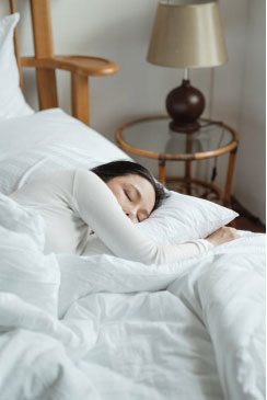 a woman sleeping on her bed